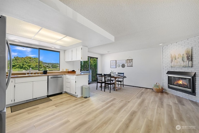 kitchen with stainless steel appliances, white cabinetry, kitchen peninsula, and a textured ceiling