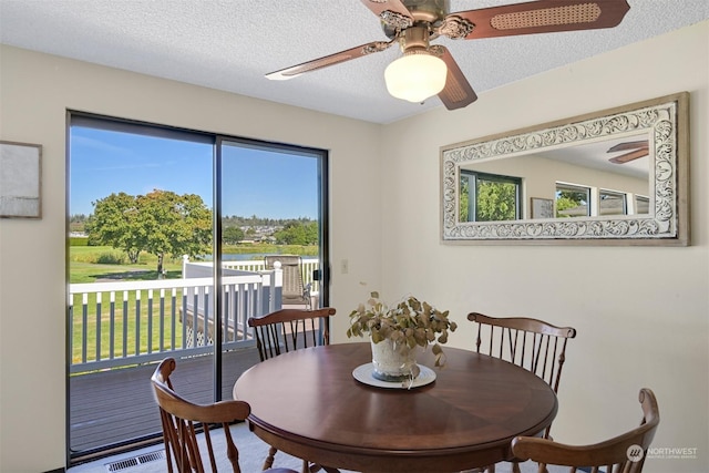 dining area featuring a textured ceiling and ceiling fan