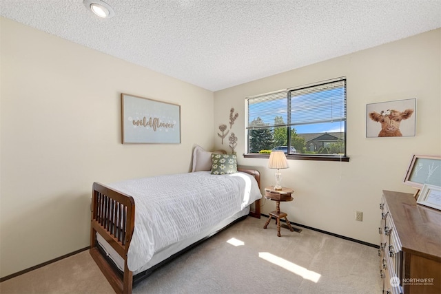 bedroom featuring light colored carpet and a textured ceiling