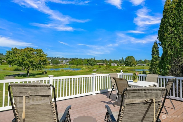 wooden deck featuring a lawn and a water view