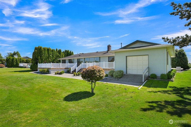 ranch-style house featuring a garage, a wooden deck, and a front lawn