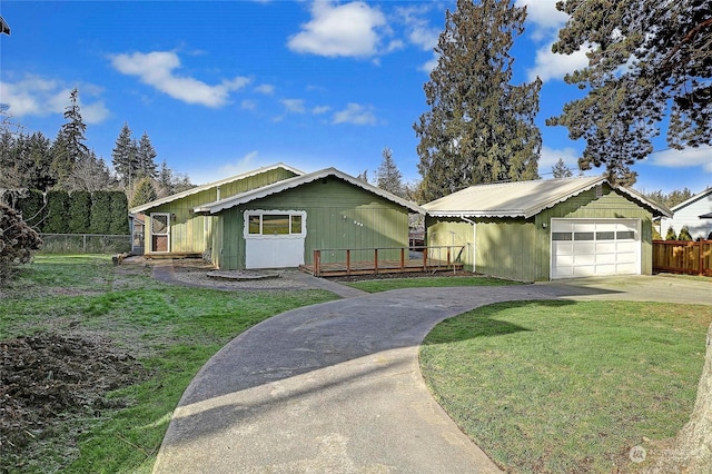 ranch-style house with a garage, a wooden deck, an outdoor structure, and a front lawn