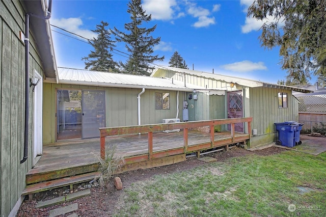 rear view of property with a lawn and a deck