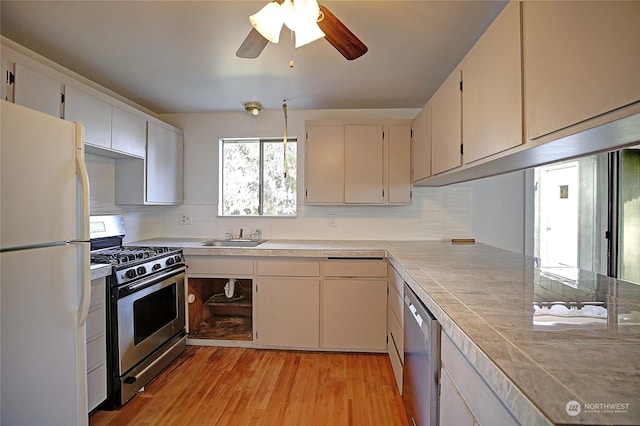 kitchen with white cabinetry, appliances with stainless steel finishes, decorative backsplash, and light hardwood / wood-style flooring