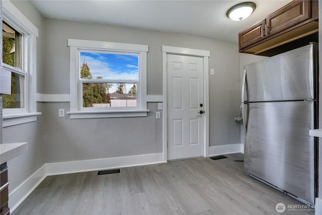 kitchen with freestanding refrigerator, light wood-style floors, and baseboards