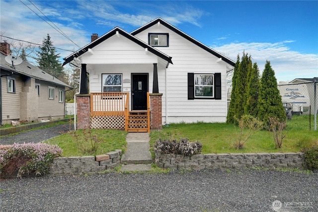 view of front of home featuring a porch, a chimney, and a front yard
