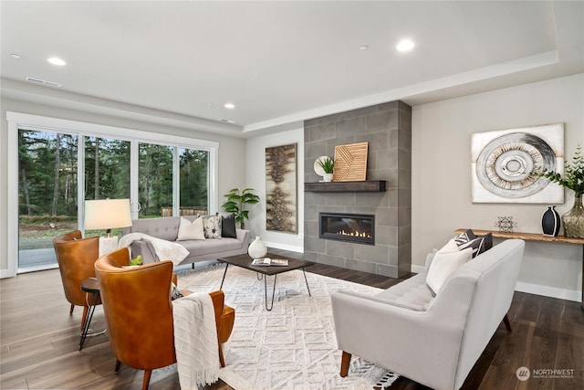 living room featuring wood-type flooring and a tile fireplace