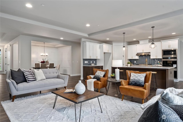 living room with sink, hardwood / wood-style floors, and a notable chandelier