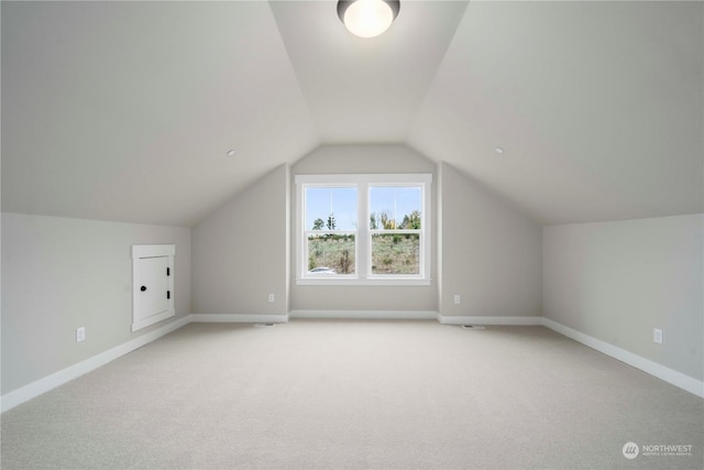 bonus room with light carpet and lofted ceiling