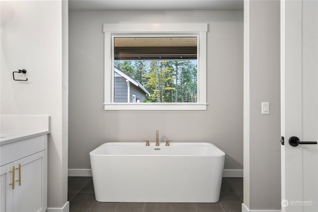 bathroom featuring a bathtub, vanity, and tile patterned flooring