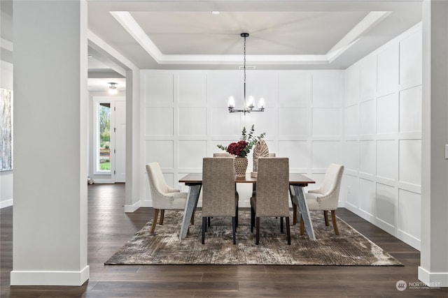 dining room featuring a tray ceiling, dark hardwood / wood-style floors, and a chandelier