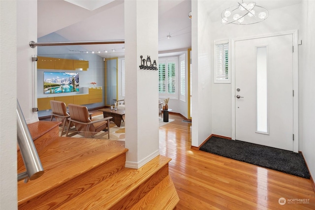 entryway featuring hardwood / wood-style flooring and a chandelier