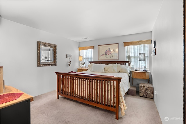 bedroom with multiple windows and light colored carpet