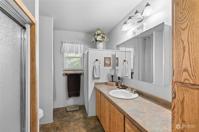 bathroom with vanity, toilet, and a shower