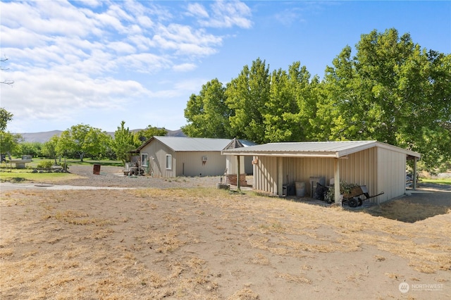 view of front of property featuring a mountain view and an outdoor structure