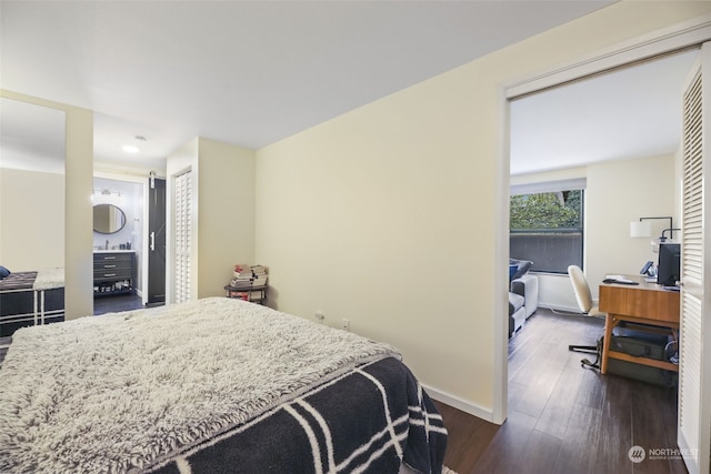 bedroom with ensuite bathroom, dark hardwood / wood-style flooring, and a closet