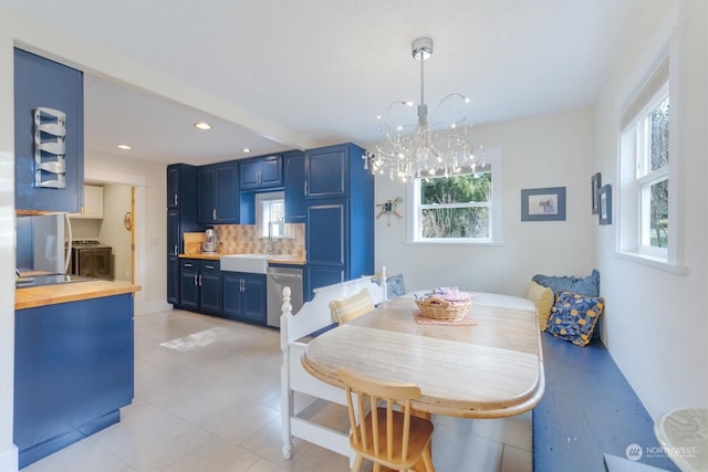 tiled dining area featuring plenty of natural light, sink, an inviting chandelier, and breakfast area