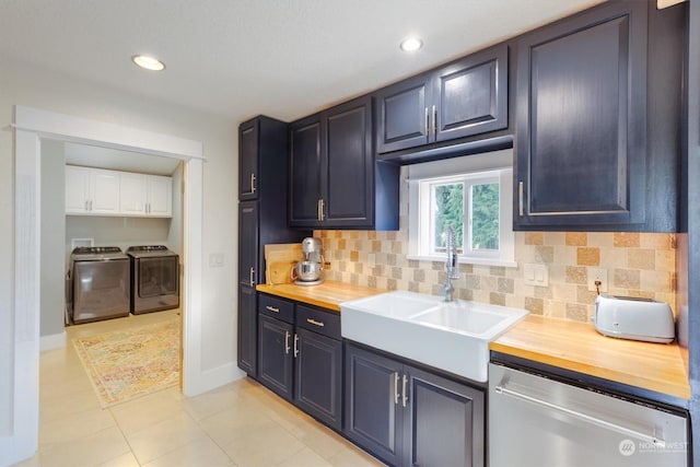 kitchen featuring stainless steel dishwasher, butcher block counters, sink, and washer and dryer