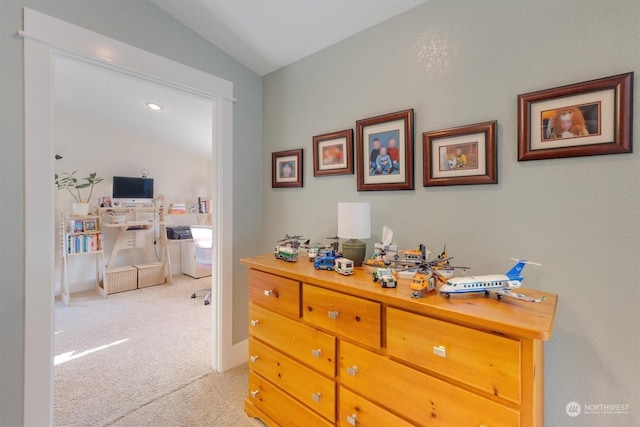 hallway featuring vaulted ceiling and light colored carpet