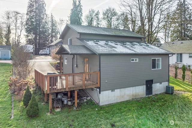 rear view of house with a wooden deck, central AC, and a lawn