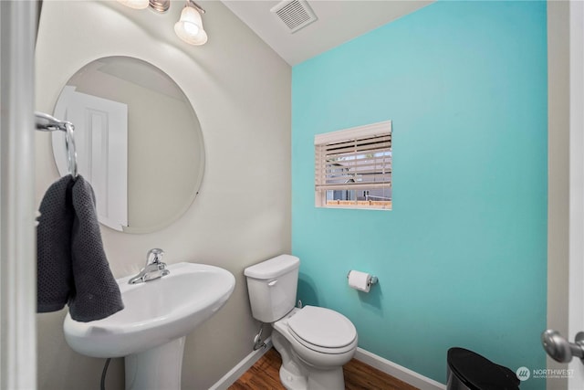 bathroom with wood-type flooring and toilet