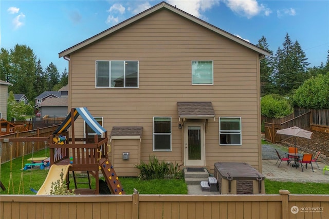 rear view of property with a patio and a playground