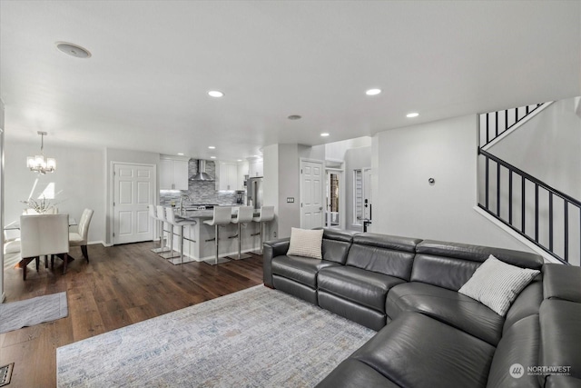 living room with dark wood-type flooring and a chandelier