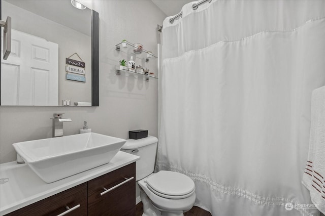 bathroom featuring a shower with curtain, vanity, and toilet