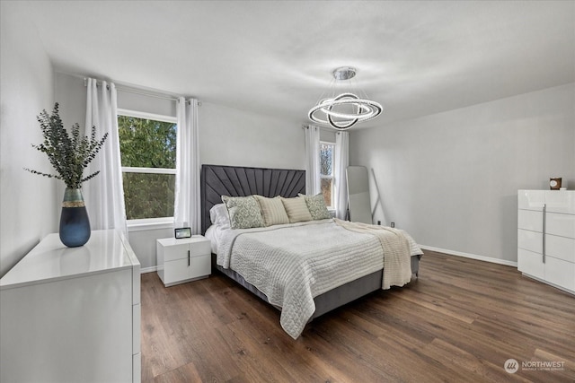 bedroom with dark hardwood / wood-style floors and a notable chandelier