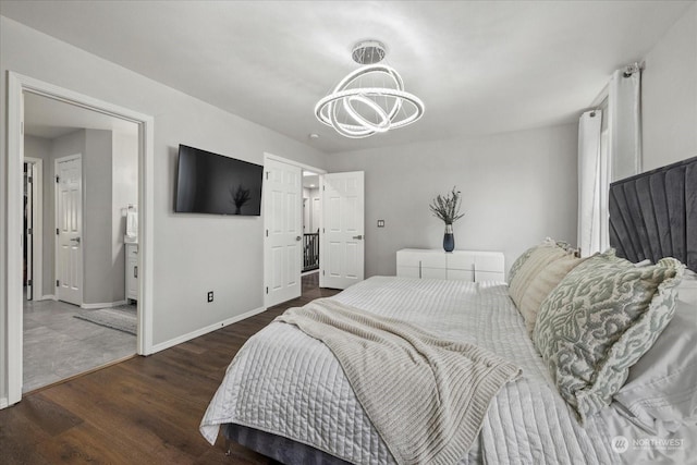 bedroom featuring ensuite bathroom, an inviting chandelier, and dark hardwood / wood-style flooring