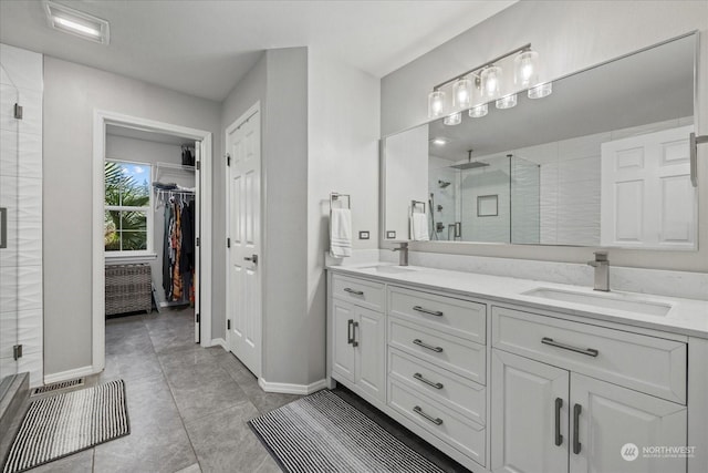 bathroom with tile patterned flooring, vanity, and walk in shower