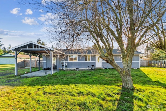 back of property with a carport and a lawn