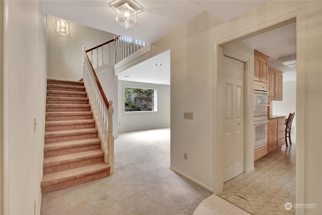 stairway featuring carpet flooring