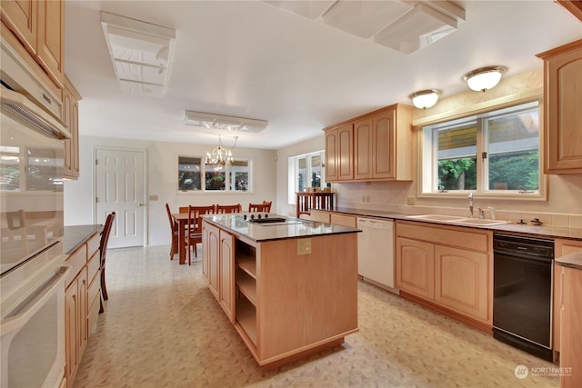 kitchen with a center island, light brown cabinetry, dishwasher, hanging light fixtures, and sink