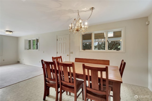 carpeted dining space featuring an inviting chandelier