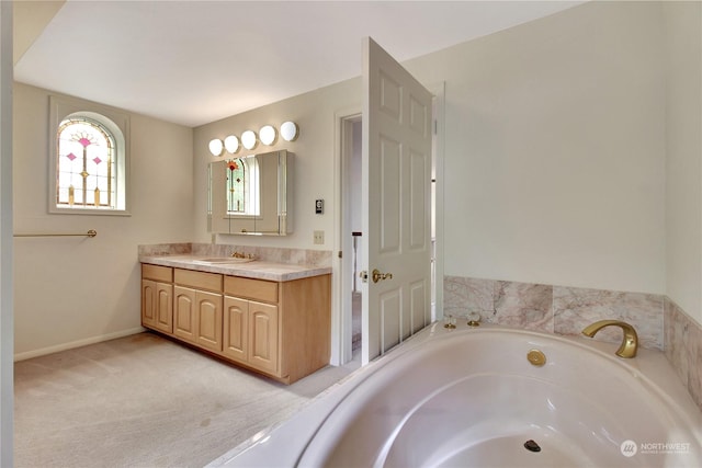 bathroom featuring a relaxing tiled tub and vanity