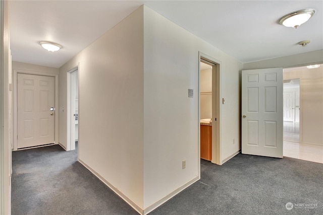 hall featuring dark colored carpet