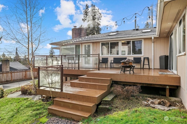 back of property featuring a deck and a fire pit