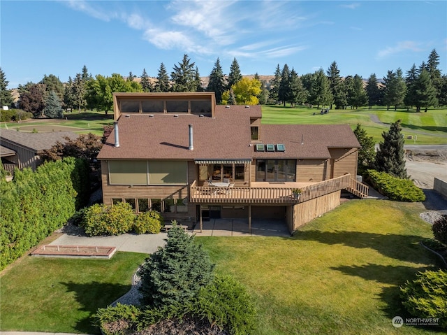 rear view of property with a patio, a lawn, and a wooden deck