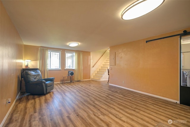 unfurnished room with hardwood / wood-style floors and a barn door