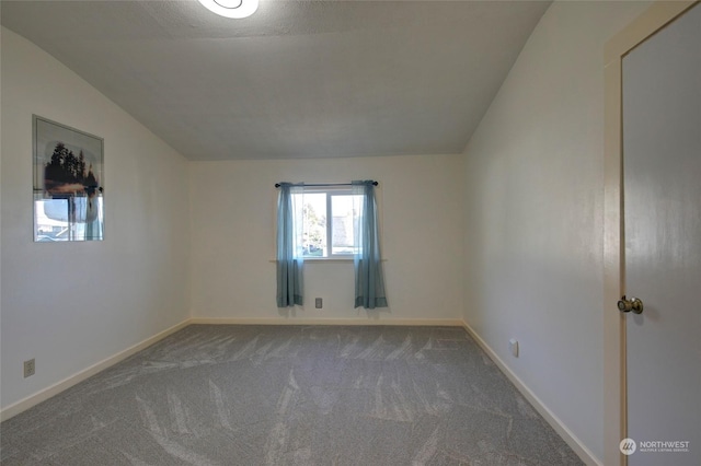 carpeted spare room with a textured ceiling and lofted ceiling