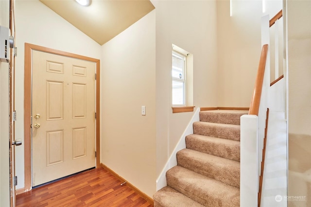 entryway with hardwood / wood-style floors and vaulted ceiling