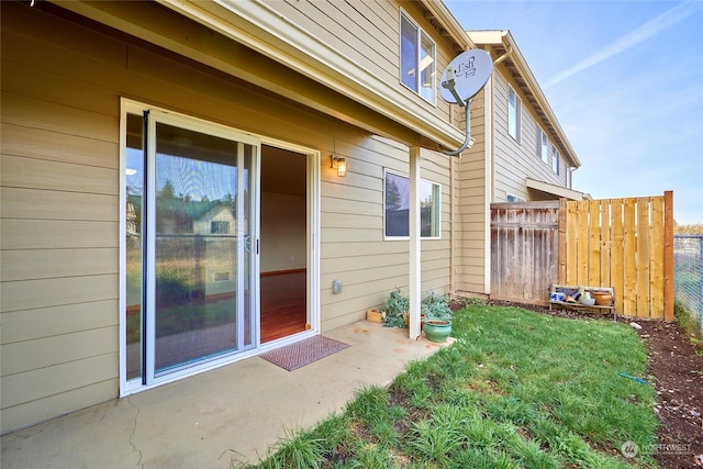 doorway to property with a lawn and a patio