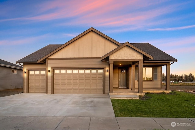 view of front of property featuring a lawn, a porch, and a garage