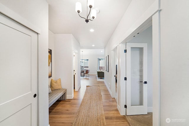 hallway featuring a chandelier and light wood-type flooring