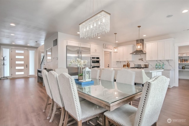 dining room featuring sink, a chandelier, and dark hardwood / wood-style flooring