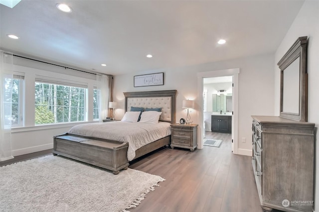 bedroom featuring connected bathroom and dark hardwood / wood-style floors