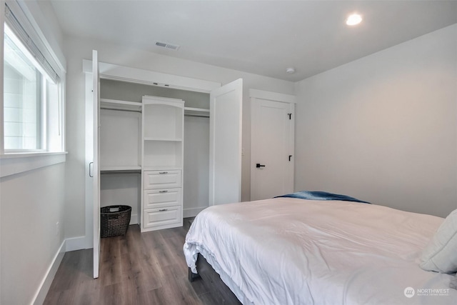 bedroom with dark hardwood / wood-style floors and a closet