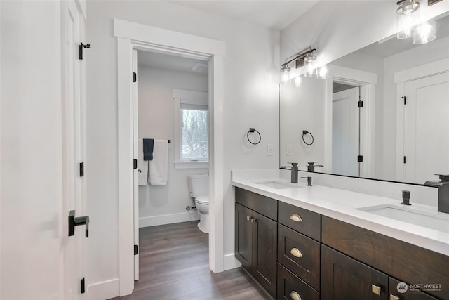 bathroom with wood-type flooring, toilet, and vanity