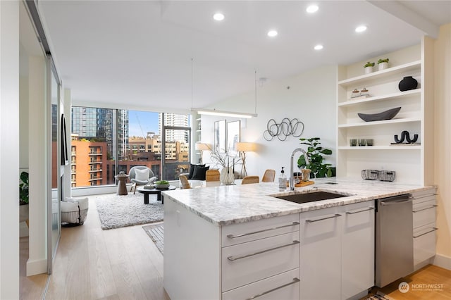 kitchen with sink, white cabinetry, light wood-type flooring, dishwasher, and light stone countertops